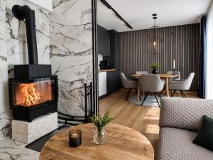 a living room with a fireplace and a table at Northern lights Ivalo Stay in Ivalo