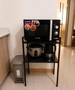 a microwave on a stand with a coffee maker and a pot at Davao City Stay at Camella Northpoint Spacious 3BR Condo 5Beds Up to 10 Guests in Davao City