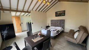 a hotel room with a bed and a table and chairs at Bosque Encantado Cabañas chalet in Guatapé