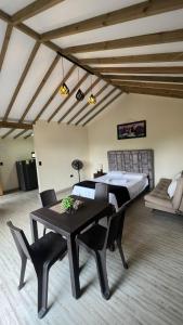 a bedroom with a bed and a table with chairs at Bosque Encantado Cabañas chalet in Guatapé