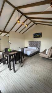 a bedroom with a bed and a table and chairs at Bosque Encantado Cabañas chalet in Guatapé