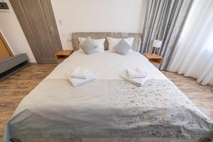 a bedroom with a large bed with two pillows on it at Pensiunea Seraris in Voineasa