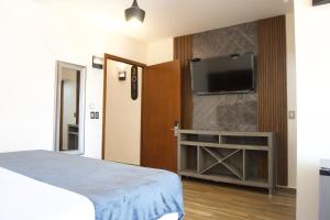 a bedroom with a bed and a flat screen tv at Gold Palace Hotel in San Juan de los Lagos