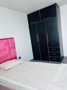 a bedroom with a pink bed and a black cabinet at Bloque 9y10 in Caracas