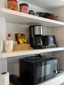 a microwave sitting on a shelf in a kitchen at RECOLETA APART in Buenos Aires +9 photos