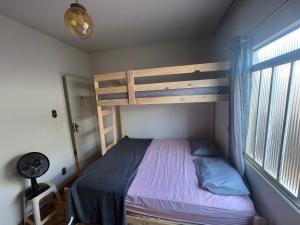 a bedroom with a bunk bed and a window at Pousada Dois Irmãos in Uberaba