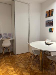 a dining room with a white table and chairs at RECOLETA APART in Buenos Aires