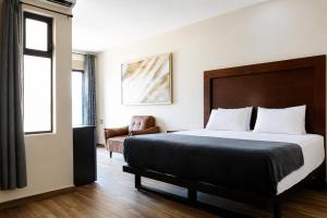 a hotel room with a bed and a chair at Gold Palace Hotel in San Juan de los Lagos