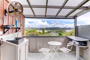a kitchen with a table and chairs on a balcony at The Tawnys Gatehouse in Russell +27 photos