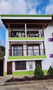 a white building with a balcony on top of it at Apartamento El Trébol 101 in Jardin
