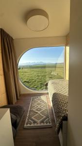 a bedroom with a large window with a view of a field at EkoHniezdo Slovenský Raj in Smižany