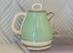 a green tea pot sitting on top of a table at Ponte Milvio Roma Elegance Room & Private Parking in Rome