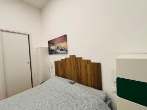 a bedroom with a bed with a wooden headboard at Il filo di Claudia in Savona