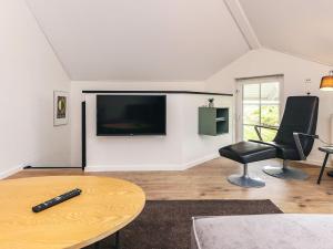 a living room with a tv and a chair and a table at 8 person holiday home in Bogense-By Traum in Bogense