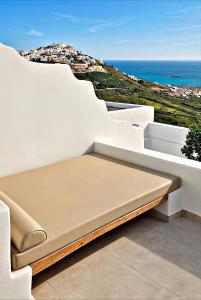 a bench sitting on the side of a white wall at Martynou View in Pyrgos