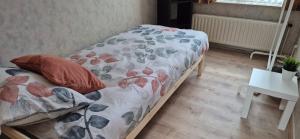 a bed with a floral comforter in a room at CoSY HOME in Mortsel +2 photos