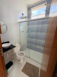 a bathroom with a shower and a toilet and a sink at Casa Cambuí Molina in Franca