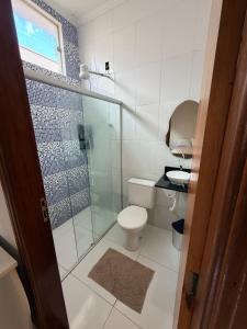 a bathroom with a toilet and a glass shower at Casa Cambuí Molina in Franca