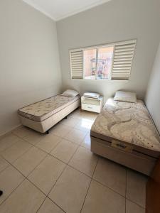 a bedroom with two beds and a window at Casa Cambuí Molina in Franca