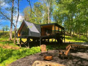 a tree house in the woods with a table and chairs at Bison Farm - Cabin "Loma" in Culpeper