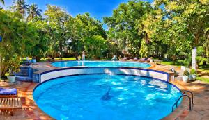 a swimming pool with trees in the background at Tranquil Middle Apartment in Mtwapa