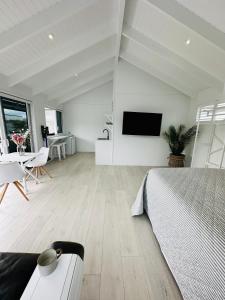 a bedroom with a bed and a table and a tv at Luxury Poolside Studio Near Hobbiton in Matamata