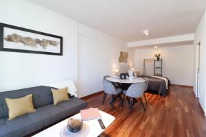 a living room with a couch and a table at SkyPort Olivos Vista al Río, Rooftop y Piscina Cubierta in Olivos +44 photos