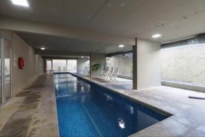 a large swimming pool in a building at SkyPort Olivos Vista al Río, Rooftop y Piscina Cubierta in Olivos