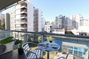 a balcony with a table and two glasses of wine at SkyPort Olivos Vista al Río, Rooftop y Piscina Cubierta in Olivos