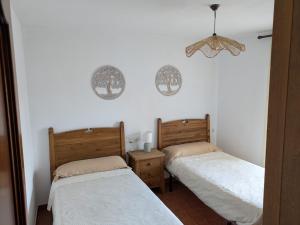 two beds in a room with white walls at At - Anita in La Alberca
