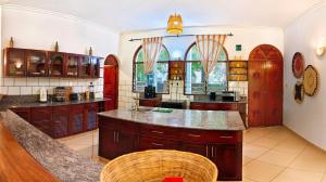 a large kitchen with wooden cabinets and a large island at The Garden Suite in Mtwapa