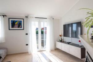 a living room with a large window and a television at Apartman Ika Umag in Umag