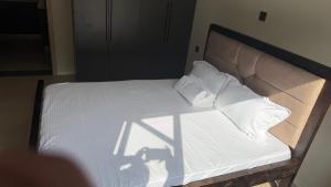 a bed with white sheets and pillows on it at Leo residences 1 in Eldoret