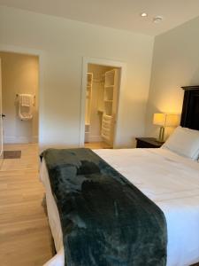 a bedroom with a large white bed and a closet at Luxury EW Bed & Breakfast in Abbotsford