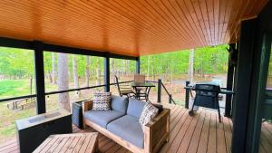 a screened in porch with a couch and a grill at Bison Farm - Cabin "Cielo" in Culpeper