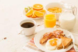 a table with a plate of eggs and toast at Paradies Caraïbes III in Les Abymes