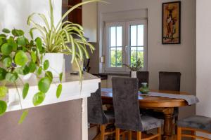 a dining room with a table and some plants at Apartman Ika Umag in Umag