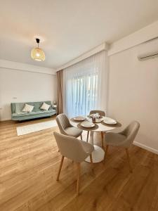 a living room with a table and chairs and a couch at Elegance Apartments in Baile Felix