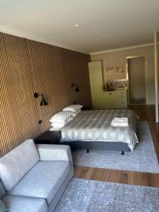 a bedroom with a bed and a couch at Gala 1 - The Old Coolstore in Merricks North