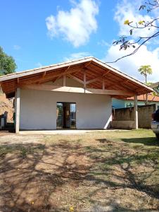 a small white building with a wooden roof at Recanto da Nonô in Gonçalves