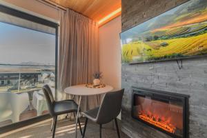 a living room with a fireplace and a table and chairs at Aurora Vista - Ohana in Lake Tekapo