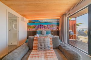 a living room with a couch and a large window at Aurora Vista - Ohana in Lake Tekapo