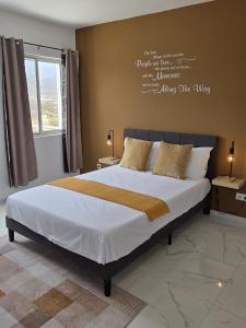 a bedroom with a bed with a writing on the wall at Tina Bay in Mindelo
