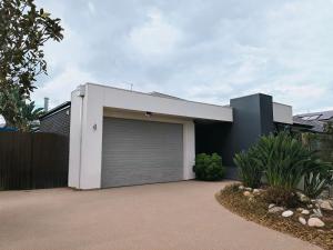 a house with a garage door in front of it at La Maison Barwon in Connewarre