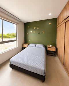a bedroom with a bed and a green wall at Casa Edén 95 in Ricaurte