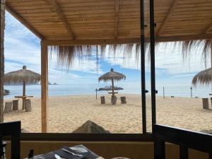 a view of a beach with umbrellas and the ocean at Paraisopingueral in Dichato