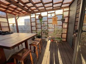 a screened in porch with a wooden table and chairs at Paraisopingueral in Dichato