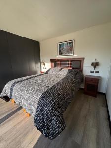 a bedroom with a bed with a black and white blanket at Paraisopingueral in Dichato +22 photos