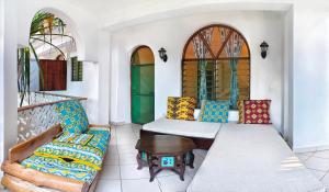 a room with a couch and a table and chairs at Tranquil Middle Apartment in Mtwapa