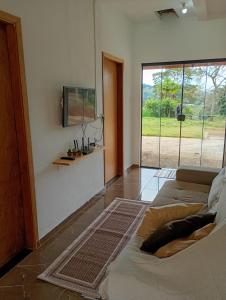 a living room with a bed and a large window at Recanto da Nonô in Gonçalves